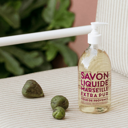 Compagnie de Provence Fig of Provence 495 ml liquid soap on a chair beside figs