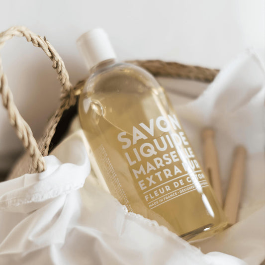 Compagnie de Provence Cotton Flower 1 L soap refill in a basket with white fabric